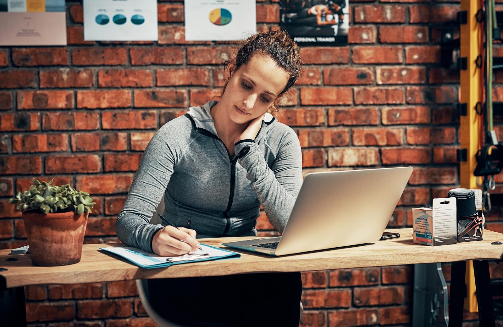 A person sitting at a desk writing on a computer

Description automatically generated